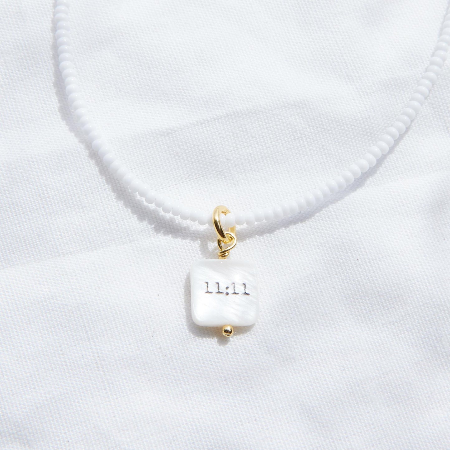 11:11 sur collier de perles de verre blanc
