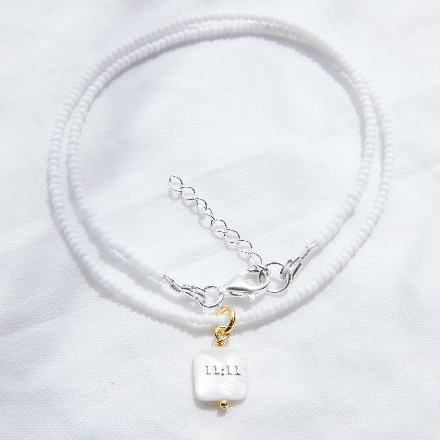 11:11 sur collier de perles de verre blanc