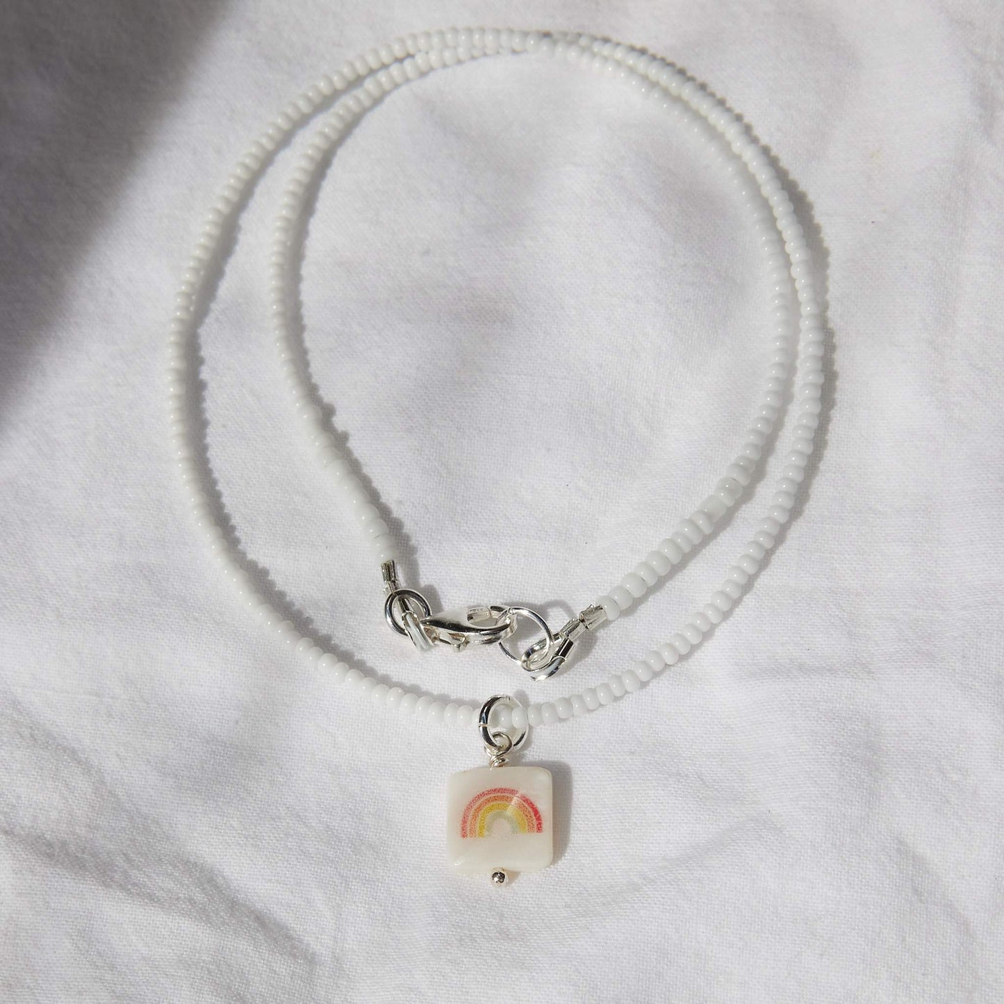 Red rainbow on white glass beads