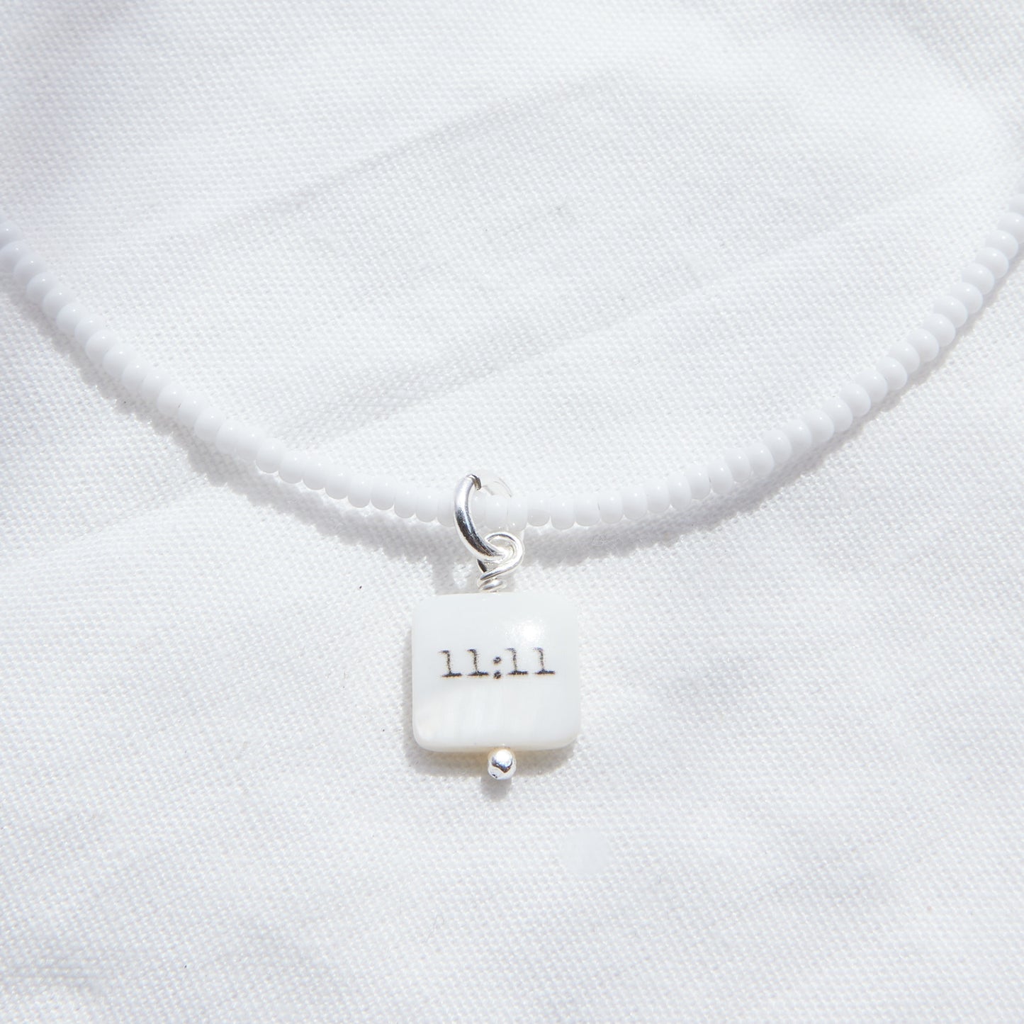 11:11 sur collier de perles de verre blanc