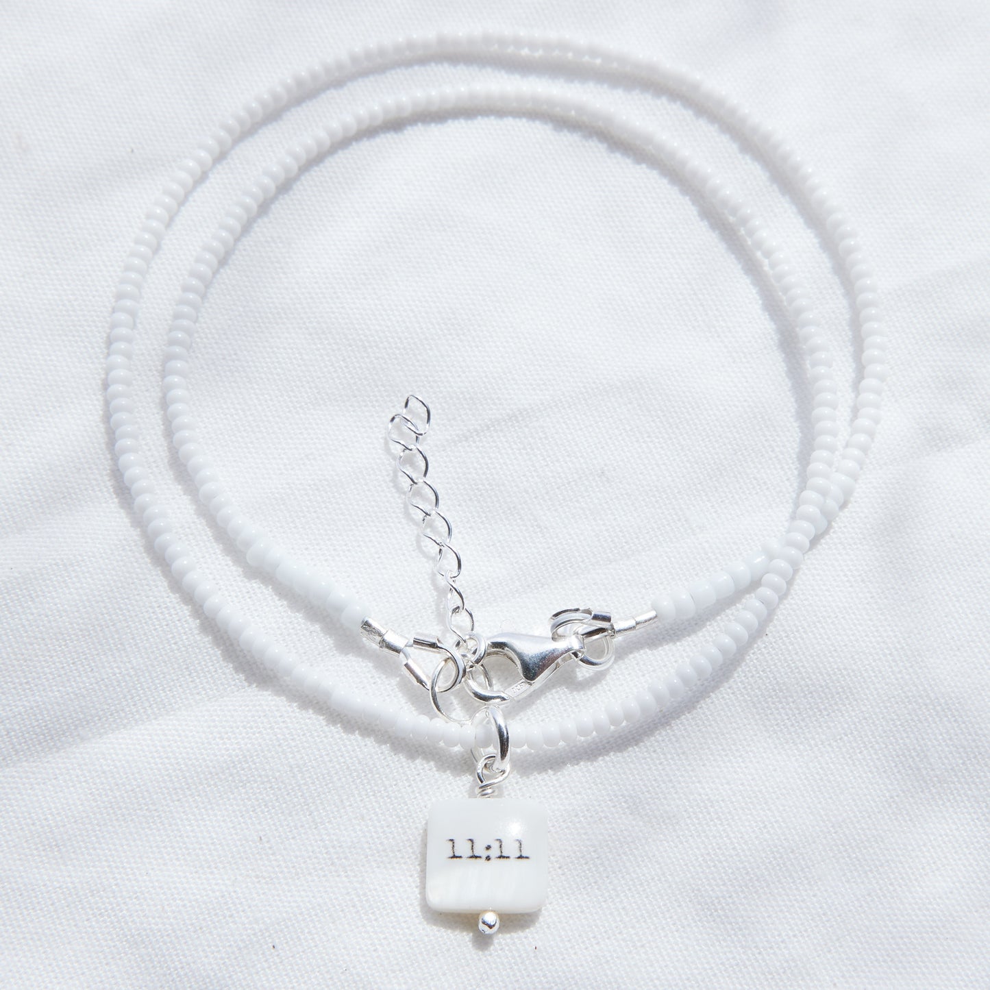 11:11 sur collier de perles de verre blanc