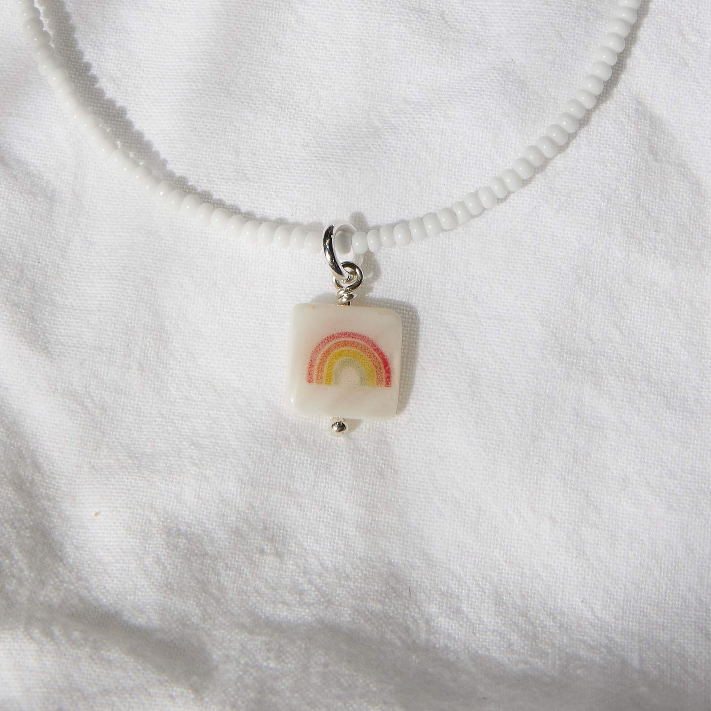 Red rainbow on white glass beads