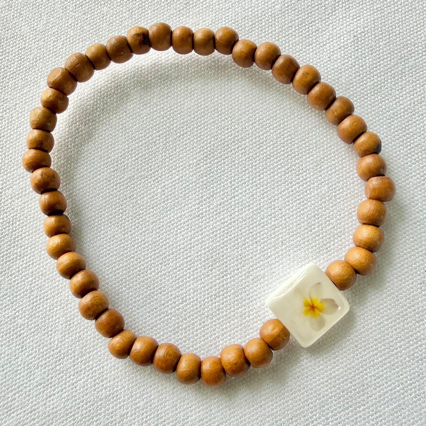 Wooden bracelet with yellow frangipani
