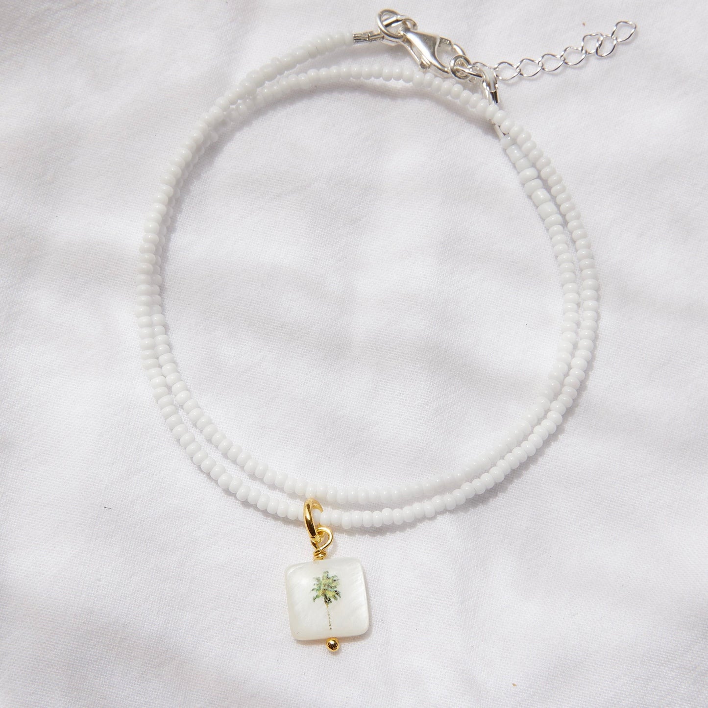 Square palm tree on white glass beads